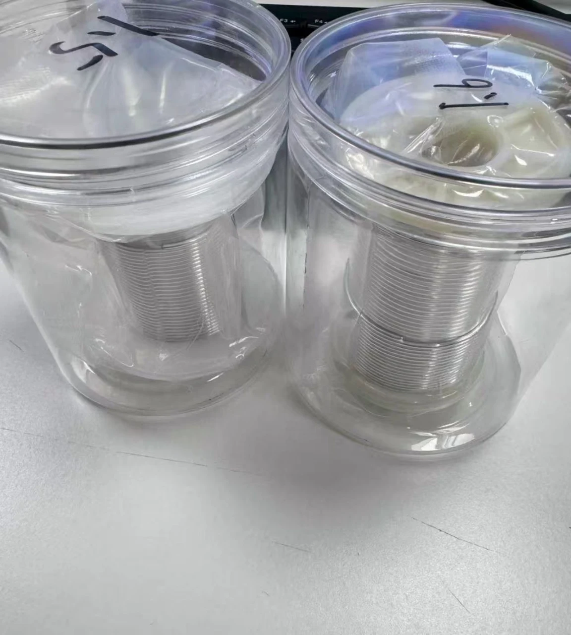 Regular 1.5 mm indium wire on the left and custom 1.6 mm wire on the right, in their labelled containers