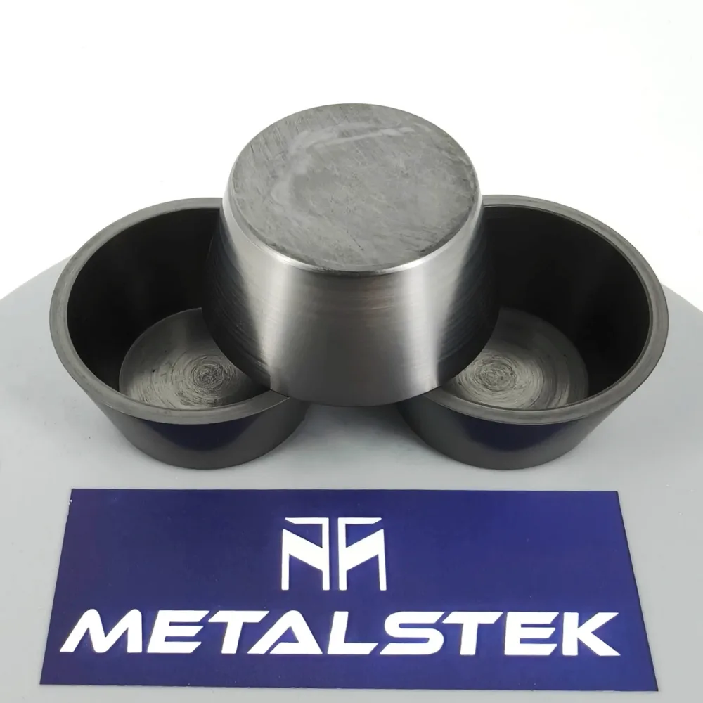 Three machined graphite crucibles with a MetalsTek card on a white background